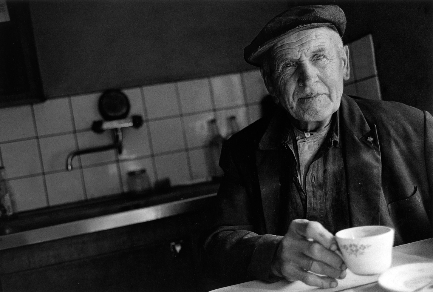 Äldre man dricker kaffe. Fotografi av Torbjörn Helgesson.