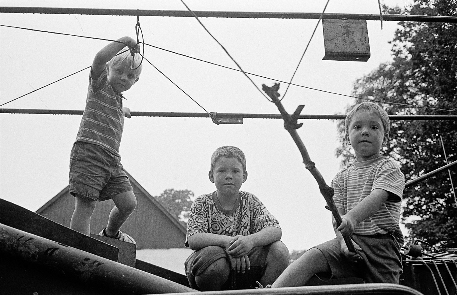 Tre pojkar på maskin. fotografi av Torbjörn Helgesson.