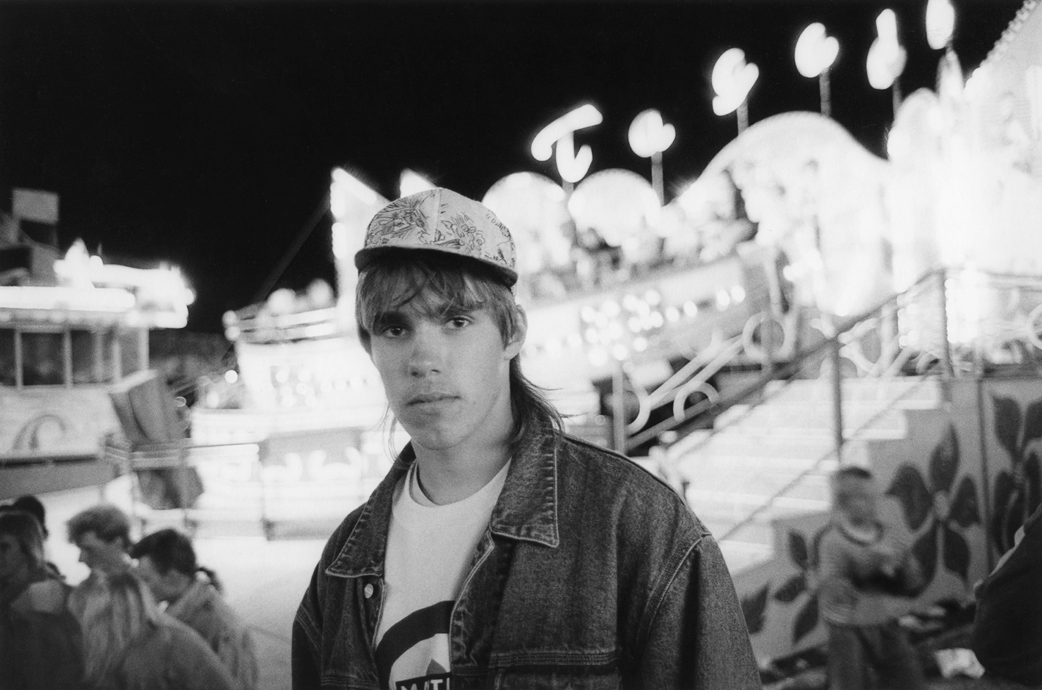 Ung man på tivoli. Fotografi av Torbjörn Helgesson.